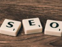 Scrabble tiles spelling out SEO on a wooden table, highlighting the importance of search engine optimization.