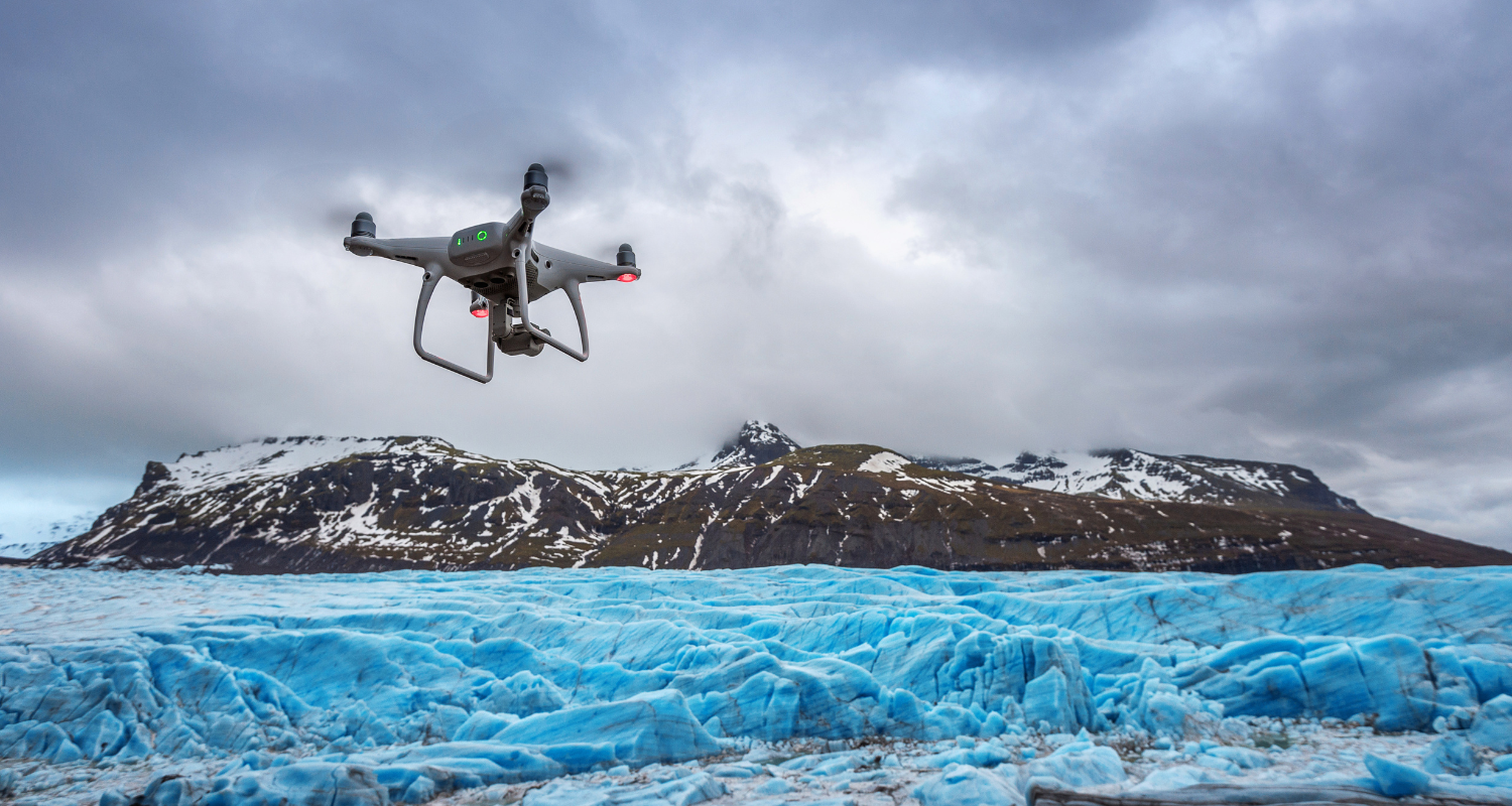 A drone flying over glacier reaching towards a mountain